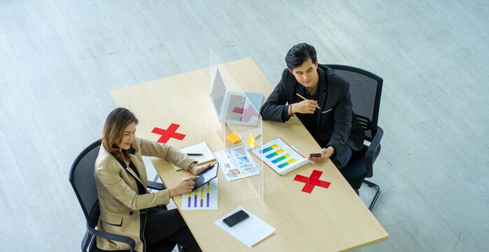 Business Man Working Apart From Colleague  In The Office. New Normal Social Distancing Concept.