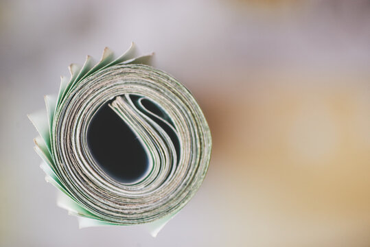 roll of one hundred euro bills against two hundred bills