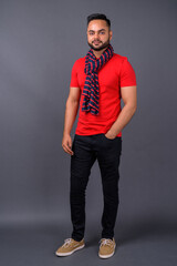 Obraz premium Young bearded Indian man against gray background
