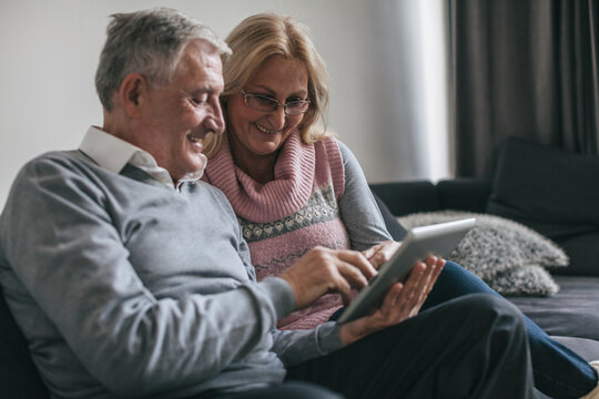 Senior Couple Using Tablet Computer and Smiling