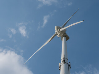 Fototapeta na wymiar Windkraftanlage vor blauem Himmel, Sicht von unten, Froschperspektive