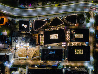 Aerial birds eye image of the office being built on a construction site at night in Vilnius. Long exposure.