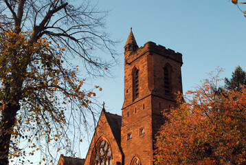 Stone Tower of Church in Warm Evening Light against Blue Sky 