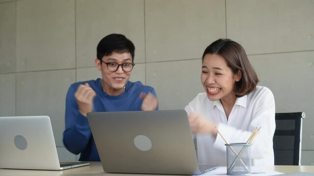 Two employees man and woman feeling excited after become winning lottery or online game bid auction for wellbeing lifestyle concept