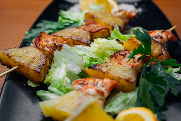 tiger prawns with pineapples in a black plate