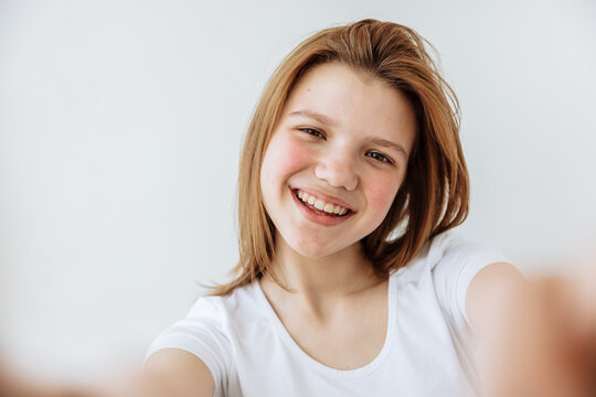 Joy emotion. Teen girl selfie portrait against white background
