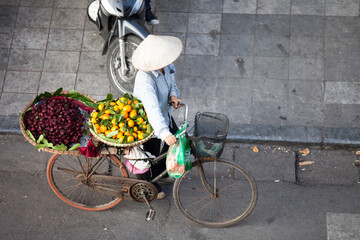 Fototapeta na wymiar HANOI, VIETNAM - FEB 21: A small market for vendor in early morning in Hanoi, Vietnam on February 21, 2016. Vietnam florist vendor selling flowers on bicycle in small market or on street in Hanoi.