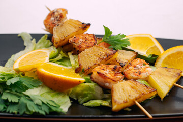 tiger prawns with pineapples in a black plate