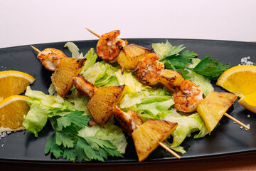 tiger prawns with pineapples in a black plate