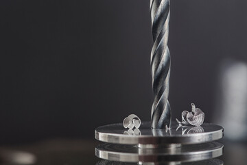 metal drill bit make holes in steel billet on industrial drilling machine. Metal work industry....