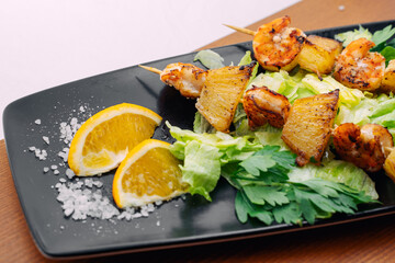 tiger prawns with pineapples in a black plate