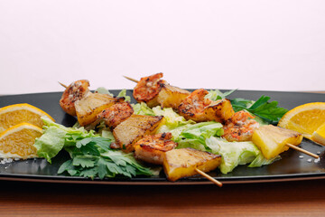 tiger prawns with pineapples in a black plate