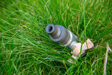 A metal faucet for watering lawns is installed on the ground in the grass.