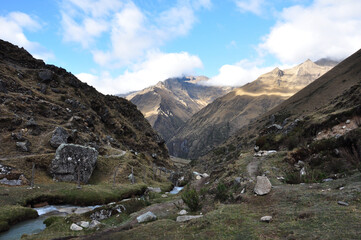 Fototapeta na wymiar A scenic view of the rocky and mountainous terrain along the Salkantay trek in Peru, with a river in the foreground