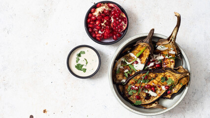 Grilled eggplants with  sauce, herbs and pomegranate