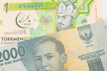 A macro image of a grey two thousand Indonesian rupiah bank note paired up with a green and yellow...