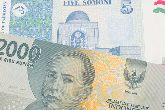 A macro image of a grey two thousand Indonesian rupiah bank note paired up with a blue and white five somoni bank note from Tajikistan.  Shot close up in macro.