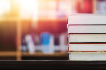 Book stack in the library and blurred bookshelf background for education. education background....