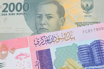 A macro image of a grey two thousand Indonesian rupiah bank note paired up with a colorful fifty pound bank note from Sudan.  Shot close up in macro.
