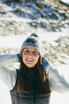 Portrait of young woman with winter hat in the snow.