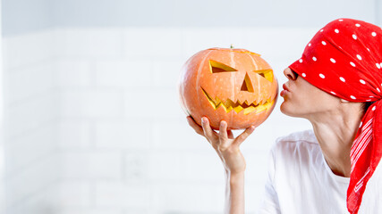 Unusual funny image of a woman with a pumpkin. Celebration of halloween 2020 with medical mask concept