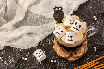 Creepy faces (monster) from marshmallows in cup of coffee for Halloween. Festive concept. Copy space
