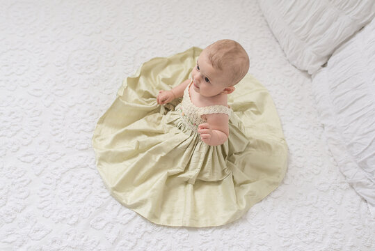 Baby On Vintage Chenille Bed In A Fancy Dress