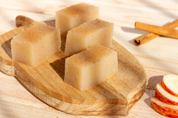 Homemade vegan apple jelly squares with cinnamon on wooden background. Rustic food style.