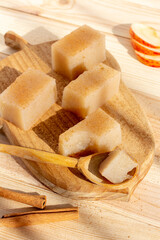 Homemade vegan apple jelly squares with cinnamon on wooden background. Rustic food style. Vertical