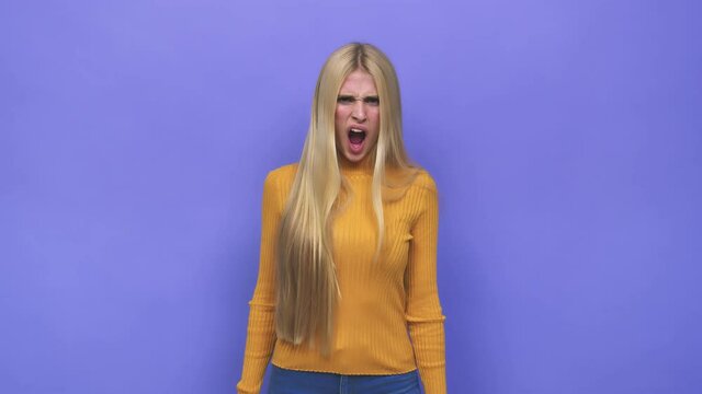 Young caucasian blonde woman screaming very angry and aggressive