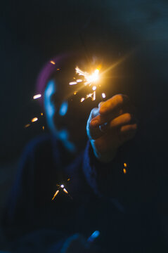 Young female smiling and holding sparkles
