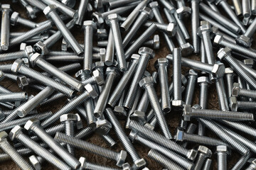 Stainless bolts on wooden background