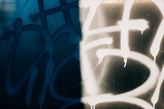 Graffiti and shadow on building wall, close up