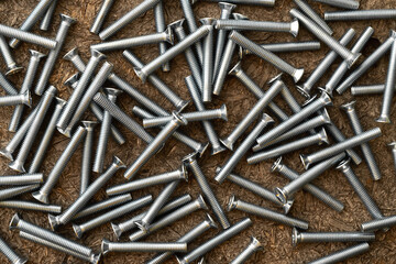 Stainless screws on wooden background