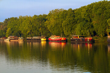 Avignon, France - 6/5/2015:  A line of canal boats on the Rhone River in Avignon.  Canal boat cruising in France is popular and diverse.