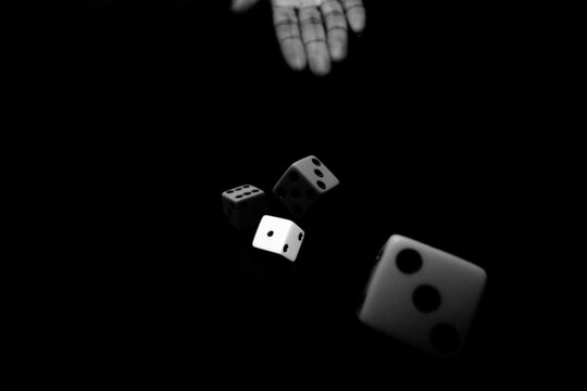Hand throwing two pairs of dice