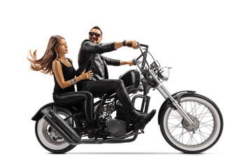Fototapeta na wymiar Biker in a leather jacket riding a young woman on a chopper motorbike and looking at her