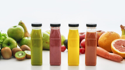 Composition of bottles of healthy detox juices and smoothies with various colorful fruits and vegetables isolated over white background
