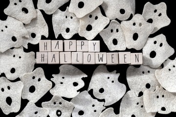 Words Happy Halloween on wooden cubes with group of scary ghost on black background, wooden cubes