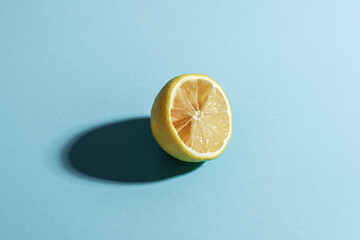 Sliced lemon on a blue background. Conceptual minimalism.