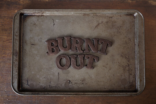 Shortbread Cookie Letters that have been burnt to a crisp, spelling out the word "burnt out"