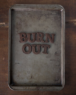 Shortbread Cookie Letters that have been burnt to a crisp, spelling out the word "burn out"