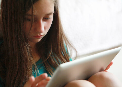 Teen Girl Concentrating While Using Her Tablet