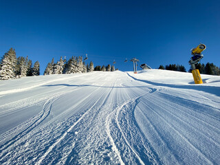 Three single traces at ski slope underneath a chairlift in the Austrian alps .