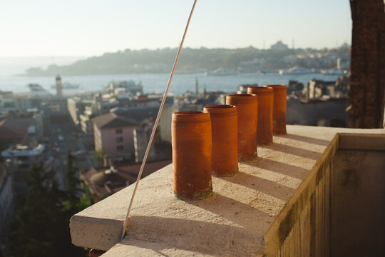 Chimney pots on an Istanbul rooftop with the city skyline beyond.