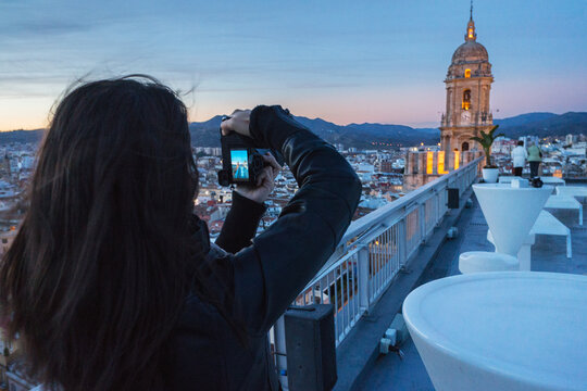 Young woman photographing Cathedral of Malaga
