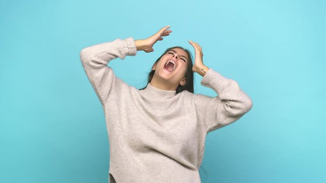 Young caucasian woman screaming to the sky, looking up, frustrated