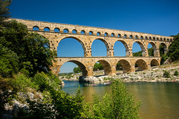 Fototapeta na wymiar Avignon, France - 6/4/2015: Pont du Gard, a Mighty aqueduct bridge rising over 3 well-preserved arched tiers, built by 1st-century Romans.