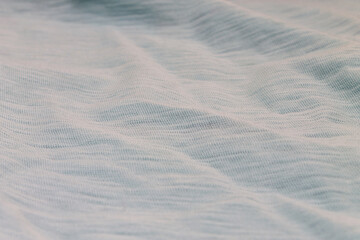 Texture background light blue color fabric closeup with folds