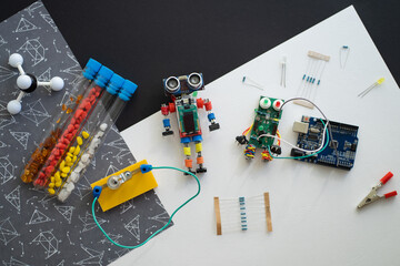 A metal robot and an electronic board that can be programmed. Robotics and electronics. DIY robotics. STEM and STEAM education for kids. Free space for text.